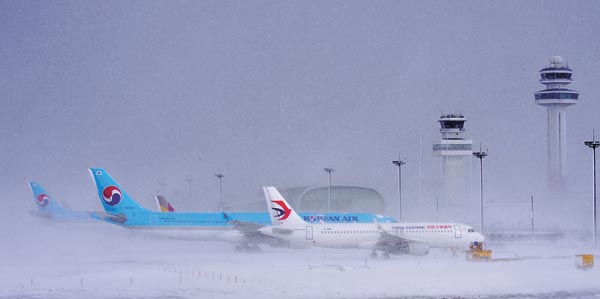 Planes stranded on the runway of Jeju International Airport on Sunday after flights were suspended Saturday afternoon due to heavy snow. [HALLA ILBO] 