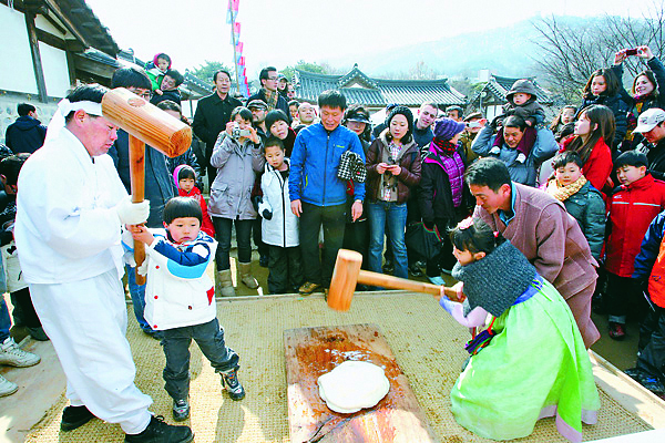 Visitors can pound rice cakes at Namsangol Hanok Village. [JoongAng Ilbo]