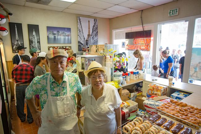 Sesame Donuts owners Jin-woong Kim and Jennifer Kim as they take customers on the day of their 27-year anniversary. (photo provided by Erika Thornes)