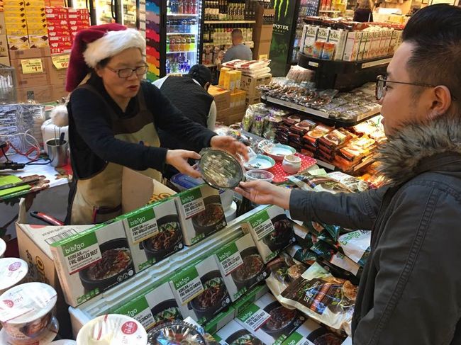 “Cup rice” is growing in popularity. A customer at Zion Market is looking at new cup rice items recently released by CJ Bibigo. 