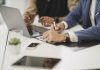 Korean American Lawmakers Falling Behind on Community-Focused Legislation Free close up of two people hands, signing documents with laptop on table in office image
