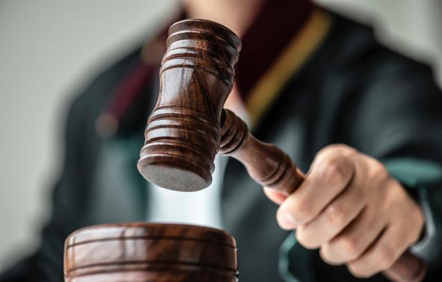 judge's hands with gavel in insurance payout lawsuit case