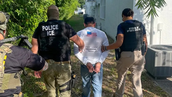 ICE agents detain a person during a deportation warrant crackdown as Federal Prosecutors Target Undocumented Inmates in California Sanctuary Jails
