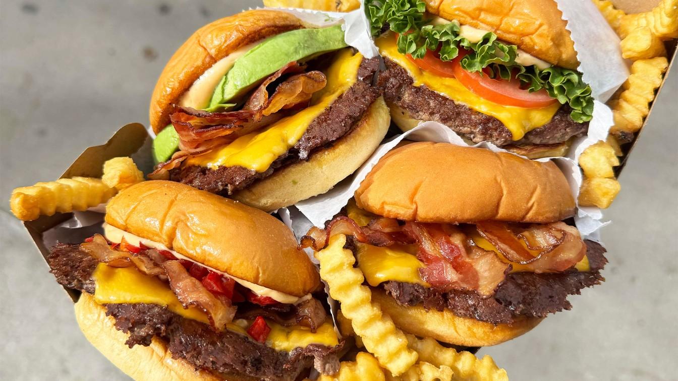 Free Shake Shack burger promotion with stacked burgers in a to-go brown paper box