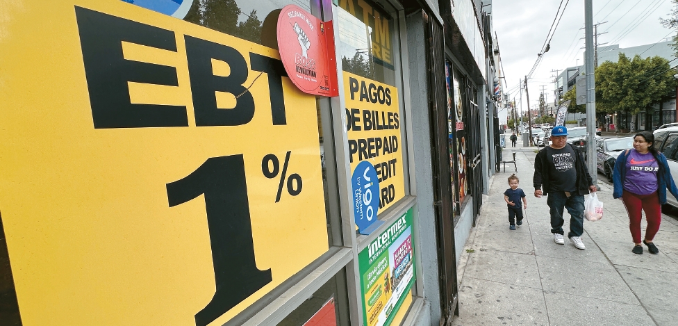 family walking past store with EBT fraud investigation sign in Los Angeles