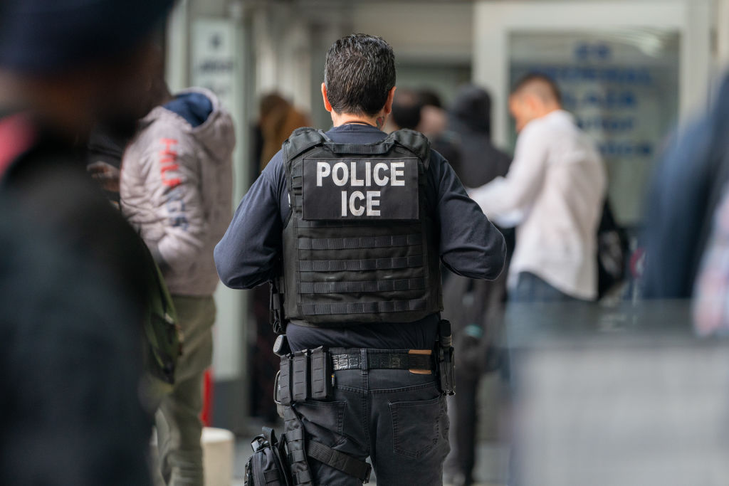 ICE agent monitors immigrants during enforcement activity in New York