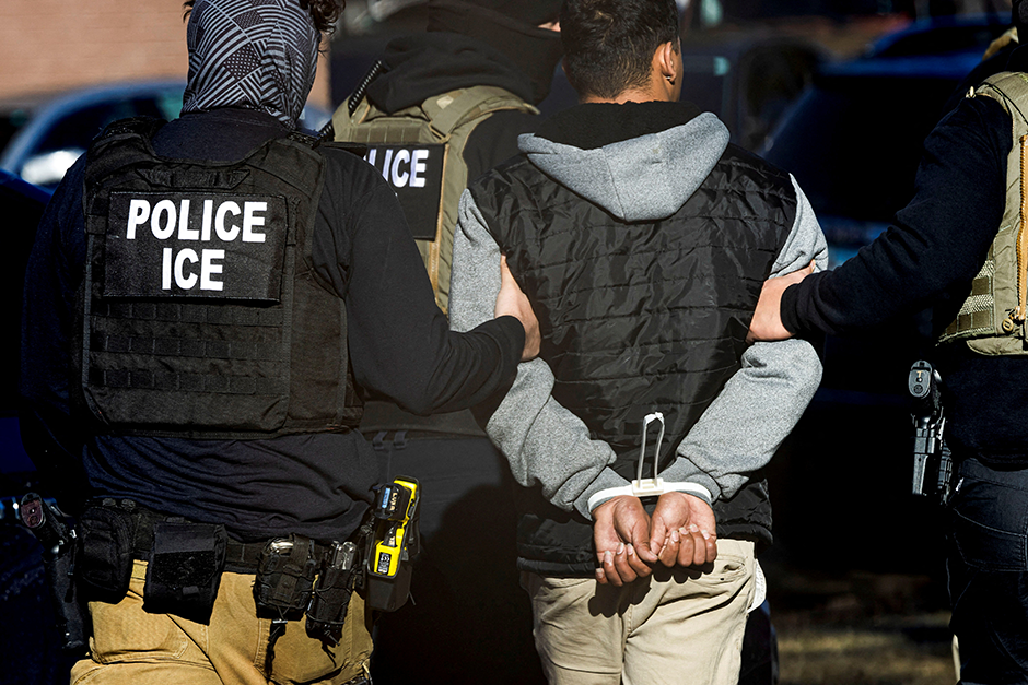 ICE agents wearing vests arresting a person during immigration raids on restaurants