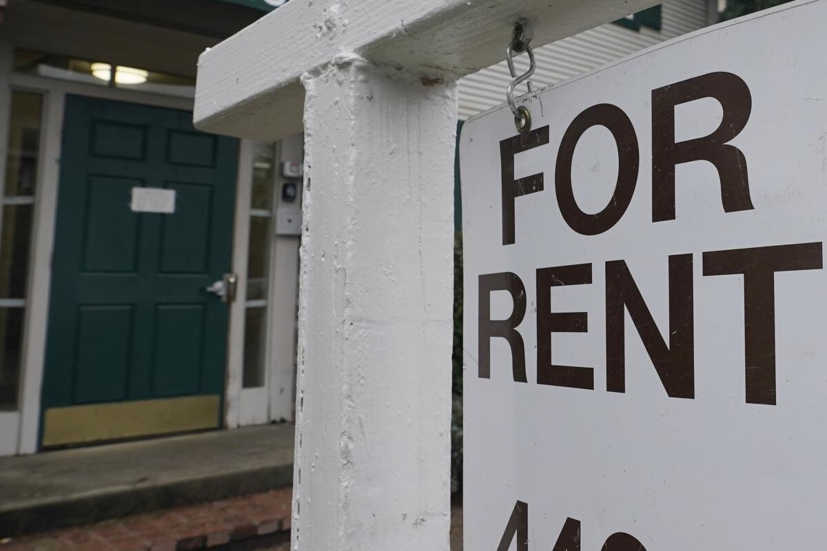 For rent sign displayed on a house door, illustrating housing aid cuts and rental market challenges