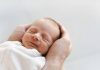 ‘Only Child Revolution’: Soaring Costs Make U.S. Parents Stop at One Newborn baby sleeping in father’s hands, representing MAGA baby investment account concept
