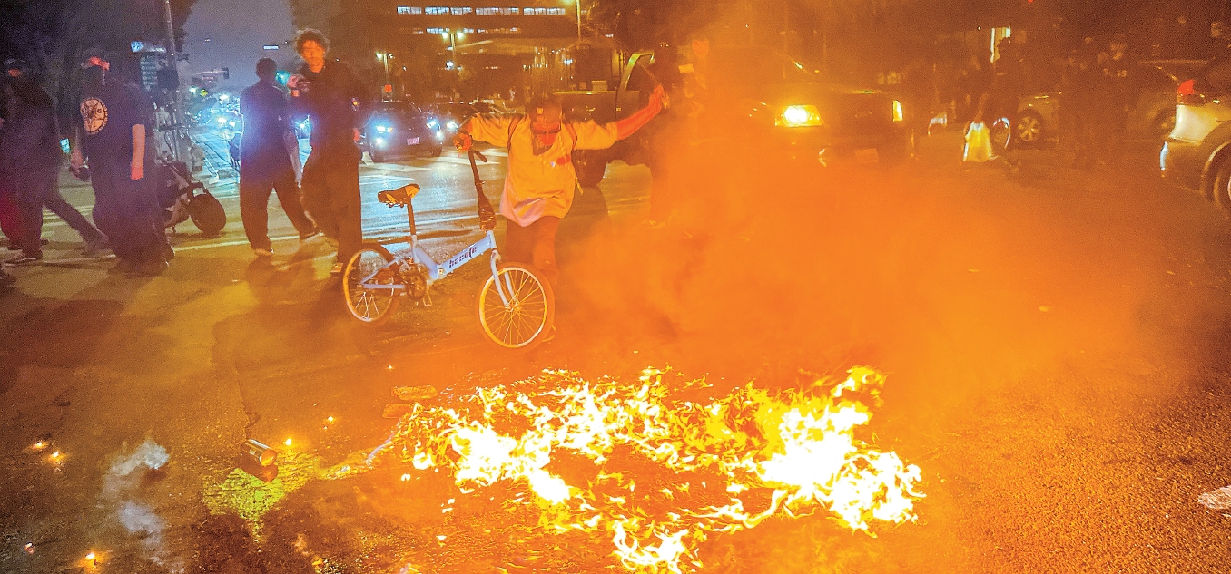 Protesters burn plastic barricades near LA City Hall during late-night immigration protests