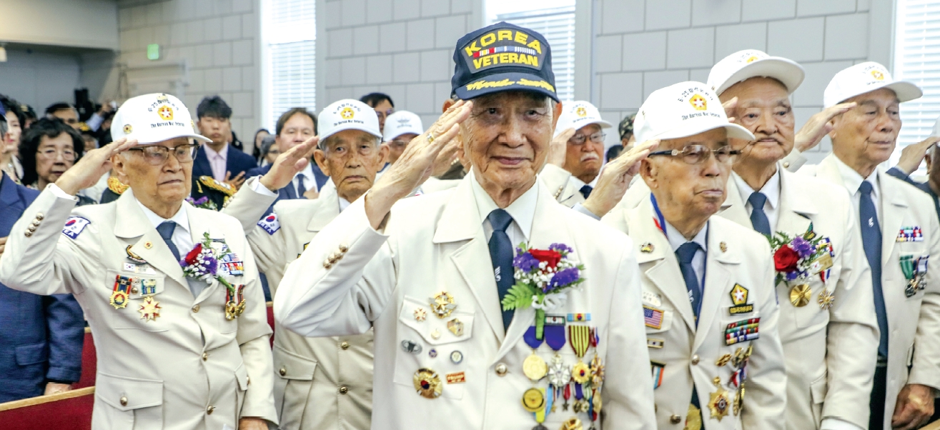 Elderly Korean War veterans salute the flag during the 75th anniversary ceremony at Saehan Church in Los Angeles
