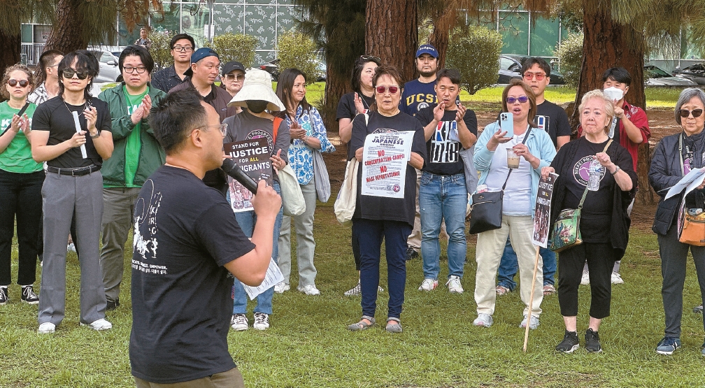 Protesters listen to Isaac Kim of NAKASEC speak during an immigrant rights rally at Liberty Park in LA Koreatown