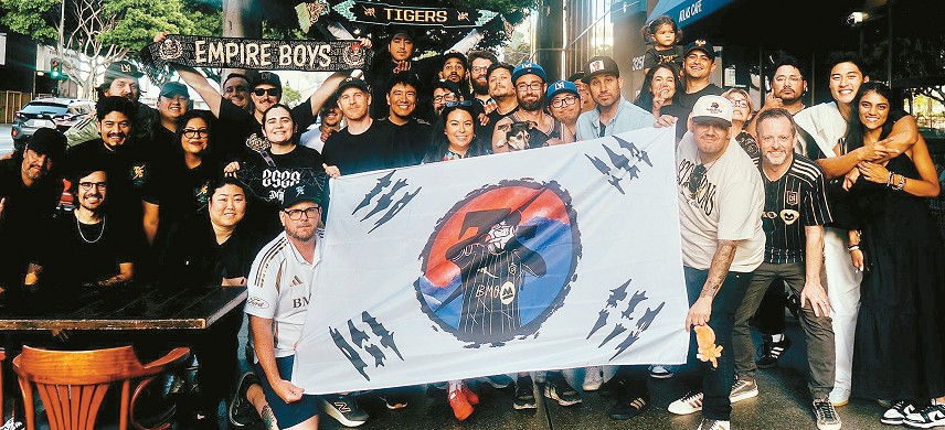 TSG members in Koreatown hold a Taegukgi with Son Heung-Min celebration after watching his first start against New England