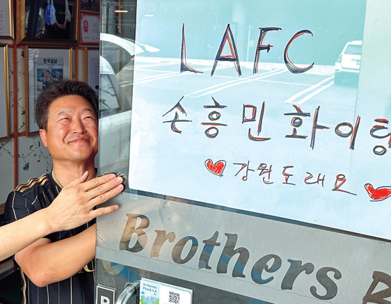Hyungje Galbi co-owner Jubu Kwon puts up a Son Heung-Min support poster for LAFC home debut