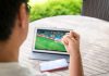 ACE dismantles illegal sports streaming giant Streamast with 1.6B visits Man cheering with fist raised while watching soccer on digital tablet, symbolizing illegal sports streaming and online live sports viewing