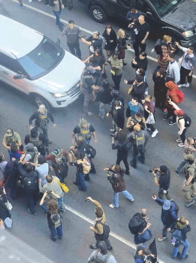 ICE agents conduct a large-scale immigration raid on Lafayette Street near Chinatown, New York, on Oct. 21, as crowds of residents gather in protest.