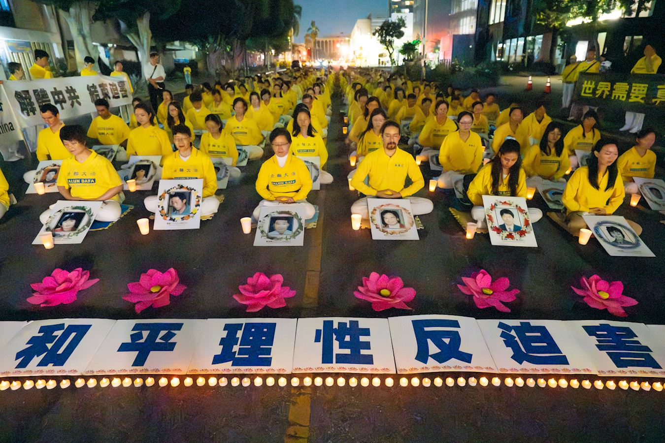 Falun Gong practitioners sit in rows holding banners protesting forced organ harvesting outside the Chinese Consulate in LA in 2024