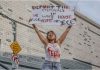 Stop Blaming Politics – Know Your Visa vs. Status Before It’s Too Late A protester holds a sign during a DTLA demonstration on June 14 regarding immigration status concerns.