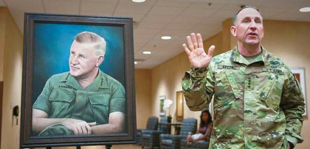 Robert Abrams speaks beside his father’s portrait during the 2015 Abrams Hall dedication ceremony at Fort Benning, Georgia, honoring the Abrams military legacy and highlighting China intervention Korea context.