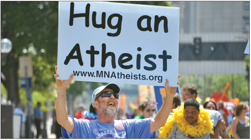 Man holding a cardboard sign reading “Hug an Atheist,” symbolizing empathy and connection within the Zealous Atheists study on nonreligious communities.
