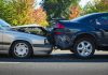 Staged Crash Fraud Spreads in California, Targeting Rideshare Vehicles Two cars sit damaged after a collision on a city street, reflecting the rise in suspected staged crash fraud cases across California.