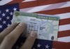 A Missed Address Update Left a Green Card Applicant in Handcuffs Permanent resident green card placed on a United States flag, highlighting an immigration address change issue.