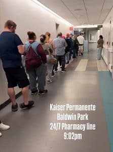 Patients stand in a long line outside the pharmacy at Kaiser Permanente Hospital in Baldwin Park. [X screenshot]