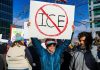 ICE Employment Ban Bills Spark Debate in Democratic States Protester holds sign with "no ice" symbol.